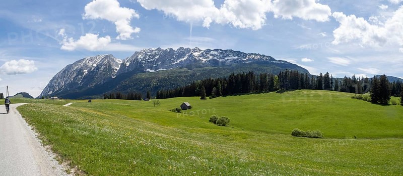 Meadow at the edge of the forest, behind the Grimming, cyclist on the Salzkammergut cycle path, panoramic shot, near Bad Mitterndorf, Styria, Austria, Europe