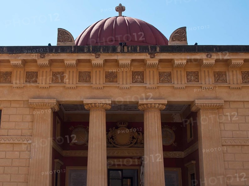 An impressive facade with columns and a dome in the background, palermo in sicily with an impressive cathedral, monuments and old houses with balconies, palm trees and flowers in italy, palermo, sicily