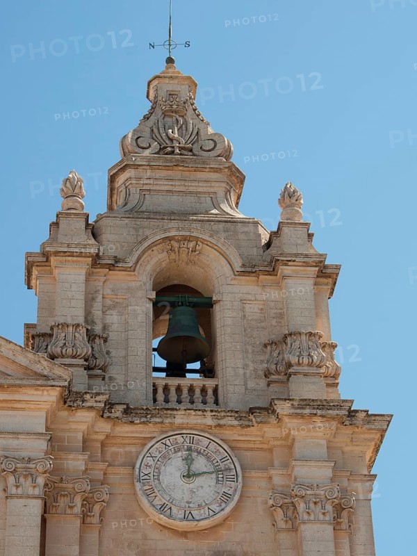 Bell tower of a baroque church with clock under a clear sky, the town of mdina on the island of malta with historic houses, colourful balconies, magnificent churches, mdina, Malta, Europe