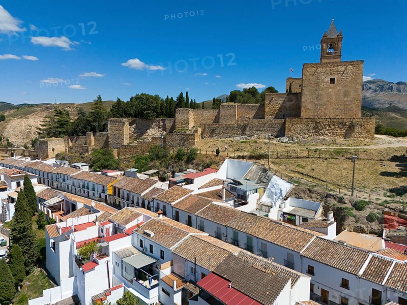 Aerial view of a medieval fortress with neighbouring houses with white walls on a sunny day, Alcazaba, Antequera, Malaga, Andalusia, Spain, Europe