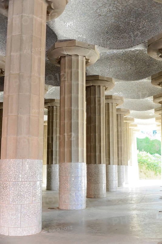 Antoni Gaudi, Park Guell, UNESCO World Heritage Site, Barcelona, Catalonia, Spain, Europe, row of columns with decorative mosaic work that emphasises the play of light and shadow on the richly textured ceiling, Europe