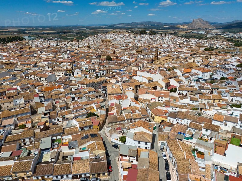 Aerial view of a picturesque spanish town with tightly packed rooftops and narrow streets surrounded by desert and mountains, Antequera, Malaga, Andalucia, Spain, Europe
