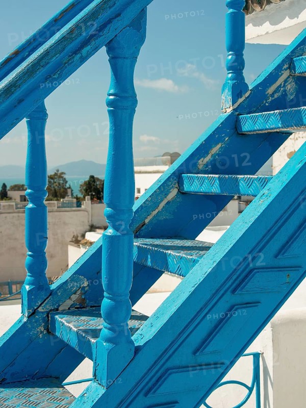 Close-up of a blue staircase with a view of the sea and white buildings, Tunis in Africa with ruins from Roman times, modern mosques and blue and white houses in sidi-bou-said, Tunis, Tunisia, Africa