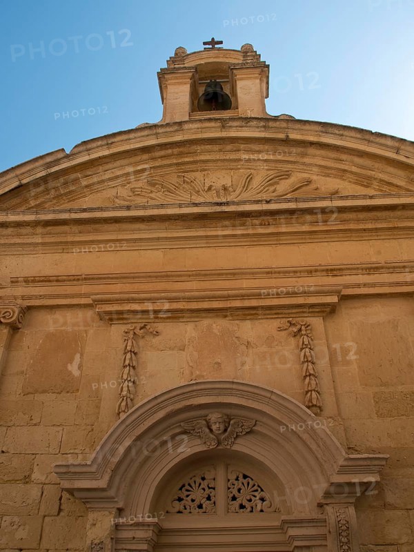 Facade of a historic church with an ornate bell tower under a clear blue sky, the town of mdina on the island of malta with historic houses, colourful balconies, magnificent churches, mdina, Malta, Europe