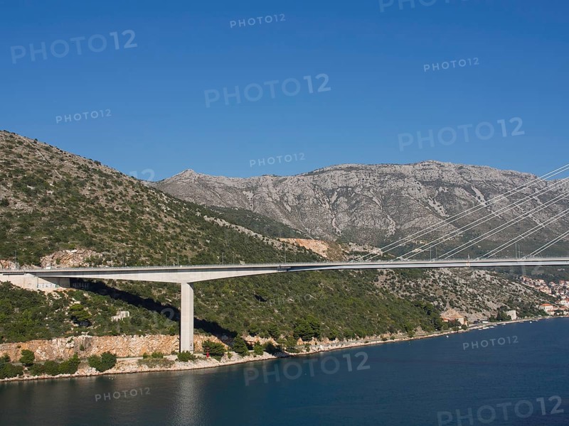 Long, modern bridge spanning a river in a picturesque mountain landscape, the old town of Dubrovnik with historic houses, churches, red roofs and fortress walls, dubrovnik, coratia