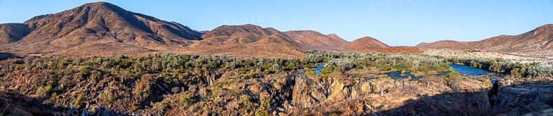 Panorama, Kunene River with green vegetation in dry red mountain landscape, waterfall and African Baobab (Adansonia digitata), in the evening light, Epupa Falls, Kunene, Namibia, Africa