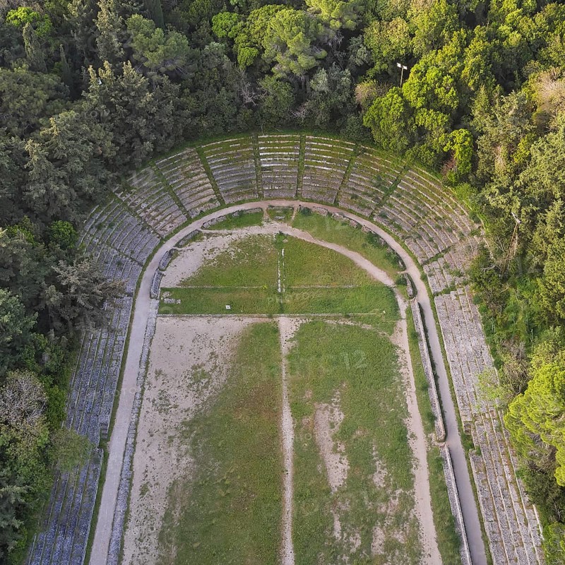 Aerial view of an ancient semicircular stadium with rows of stone seats surrounded by forest, Archaeological Site, Rhodes Town, Rhodes, Dodecanese, Greek Islands, Greece, Europe