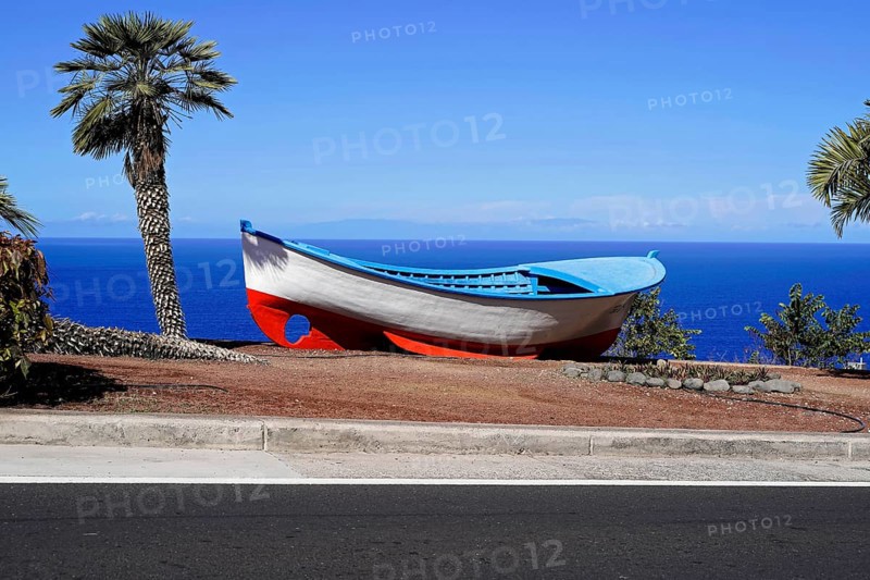 Sandy beach beach Playa de Las Teresitas, near San Andres, Tenerife, Canary Islands, Spain, Europe, A colourful boat stands on a shore next to a road, surrounded by palm trees and a deep blue sky and sea, Europe