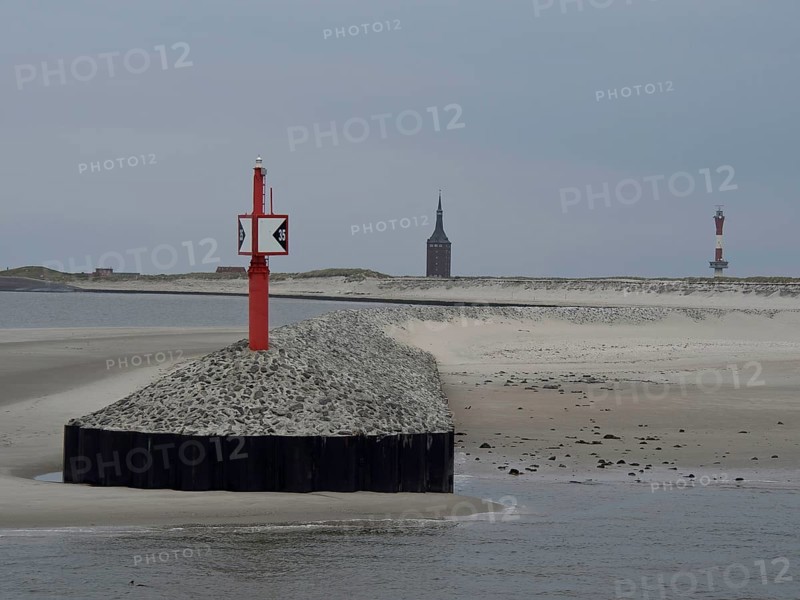 Red beacon on gravel embankment, divided coastal landscape with sand dunes and church tower in the background, buhne on an island in the north sea with tower and sea mark, Wangerooge, Germany, Europe