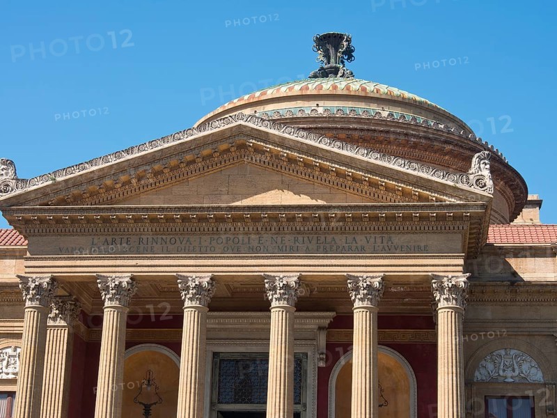 Historic building with magnificent dome and columns in front of a cloudless blue sky, palermo in sicily with an impressive cathedral, monuments and old houses with balconies, palm trees and flowers in italy, palermo, sicily