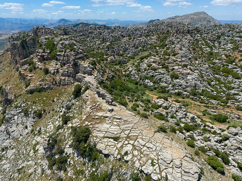 A rocky mountain landscape under a blue sky with many clouds and a rough, dry-looking surface, aerial view, karst mountains, Torcal Alto, El Torcal de Antequera, Sierra del Torcal, Malaga, Andalusia, Spain, Europe