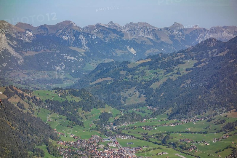 Panoramic view of a mountain landscape with a village and green meadows in a wide valley, Mountain panorama with rugged mountains and green valleys, saas fee, Switzerland, Europe