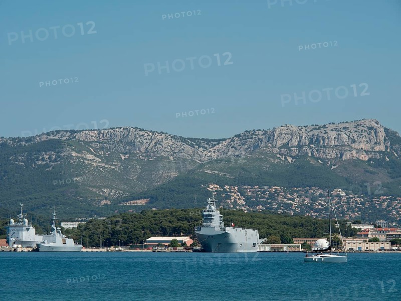 Several warships and a sailing boat in the harbour, green coast and mountain range in the background, la seyne sur mer, france