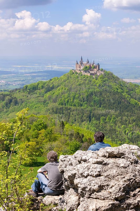Hikers looking at Hohenzollern Castle near Hechingen, cloudy sky, Zollernalbkreis, Swabian Alb, Baden-Wuerttemberg, Germany, Europe