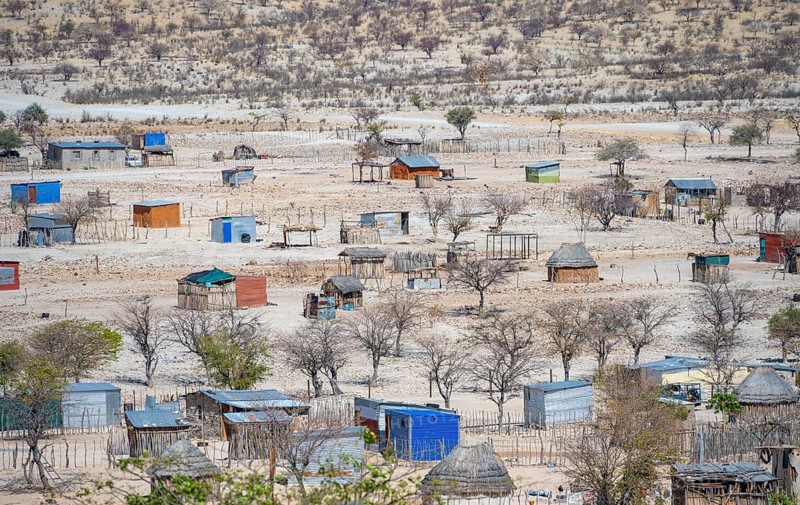 Huts and h of the village Epupa, barren dry landscape with white and yellow hills, Kaokoveld, Kunene, Namibia, Africa