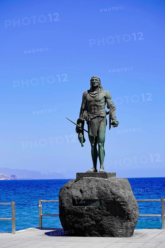 Statues of the Guanche Kings or Mencey Statues, in front Guanche King Adjona, promenade of Candelaria, Tenerife, Canary Islands, Spain, Europe, Stand-alone bronze statue of a historical figure on a stone pedestal in front of blue sky and sea, Europe