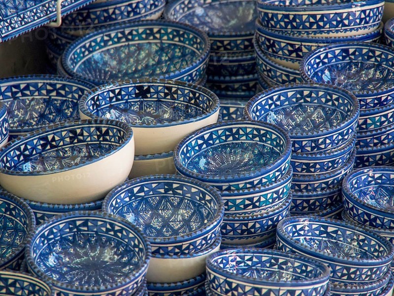 A collection of blue ceramic bowls with traditional patterns stacked on a market stall, Tunis in Africa with ruins from Roman times, modern mosques and blue and white houses in sidi-bou-said, Tunis, Tunisia, Africa