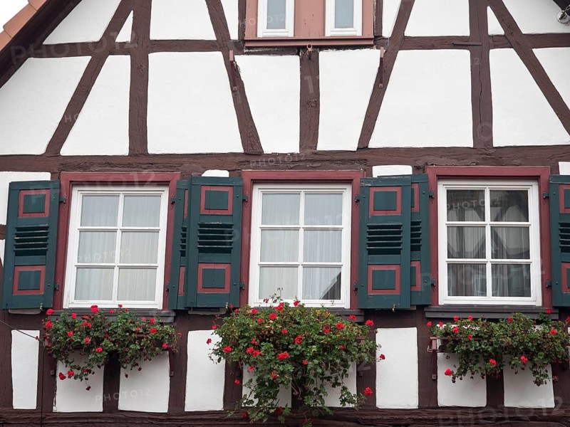 Half-timbered house with red shutters and flower boxes under the windows, kandel, germany