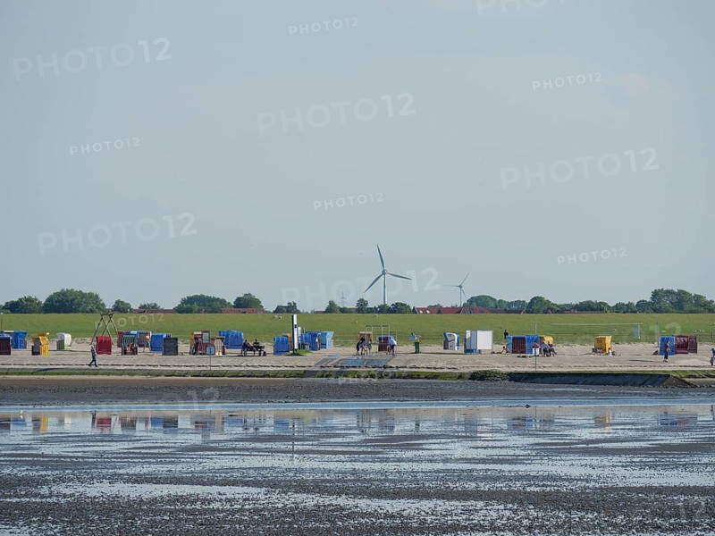 View of a coastal landscape with colourful beach chairs and wind turbines, Baltrum Germany