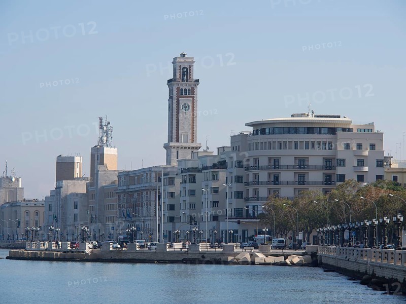 Urban landscape along the water with several buildings and harbour structures, The city of Bari on the Mediterranean with historic buildings, small boats in the harbour and beautiful churches, bari, italy
