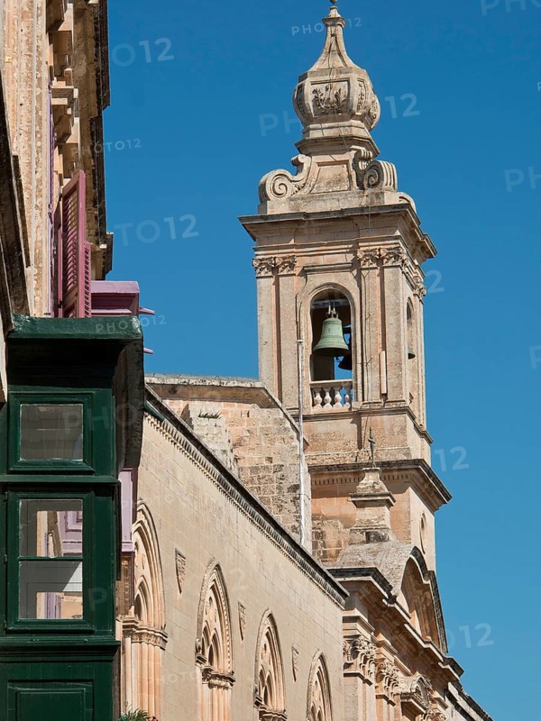 Baroque bell tower of a historic building under a clear blue sky, Historic buildings with beautiful windows, balconies and small towers, Mdina, Malta, Europe