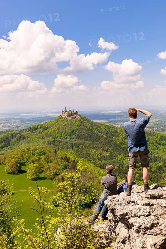 Hikers looking at Hohenzollern Castle near Hechingen, photographer, cloudy sky, Zollernalbkreis, Swabian Alb, Baden-Wuerttemberg, Germany, Europe