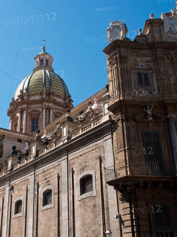 Church building with a magnificent green dome and detailed architectural elements, palermo in sicily with an impressive cathedral, monuments and old houses with balconies, palm trees and flowers in italy, palermo, sicily