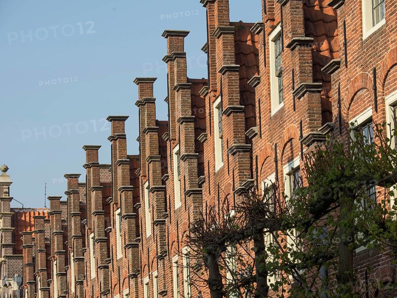 Detail of a historic brick building with distinctive gables and windows in sunny weather, Haarlem, Netherlands