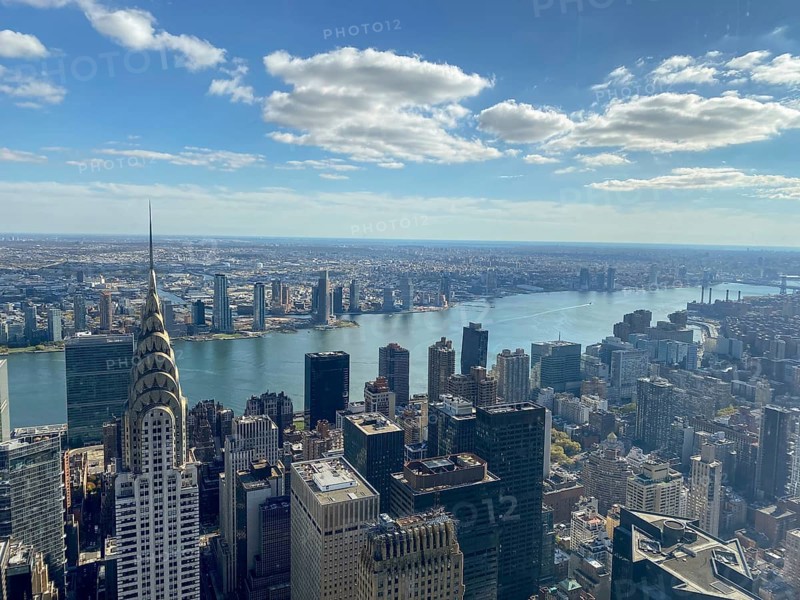 Daytime view of a large city with a view of the river and numerous skyscrapers, including the Chrysler Building with blue sky and clouds, new york from above with impressive skyscrapers and clouds in the sky, New york, USA, North America