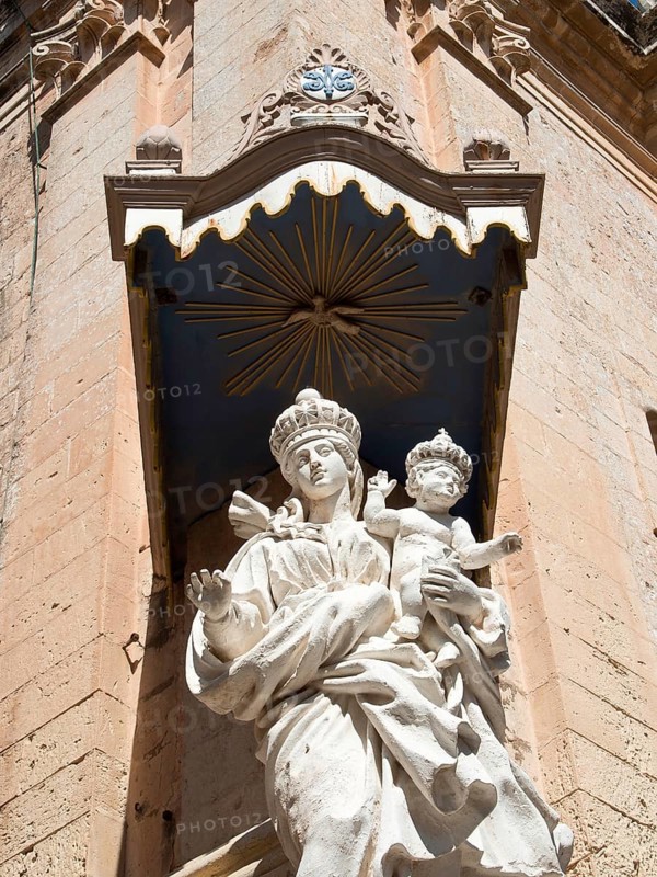 Expressive Madonna statue with child under an elaborate stone canopy on a historic facade, the town of mdina on the island of malta with historic houses, colourful balconies, magnificent churches, mdina, Malta, Europe