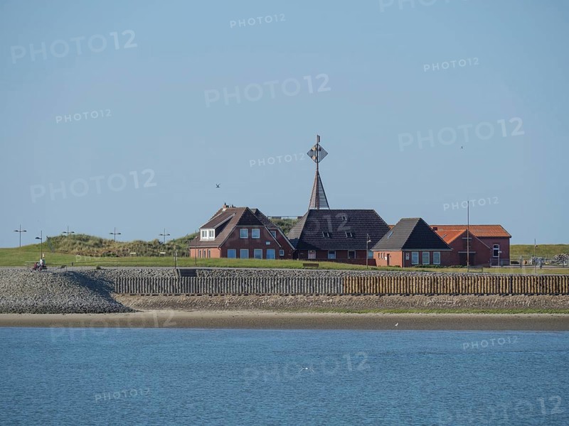 Quiet coastal scene with houses on the shore under a clear sky, Baltrum Germany