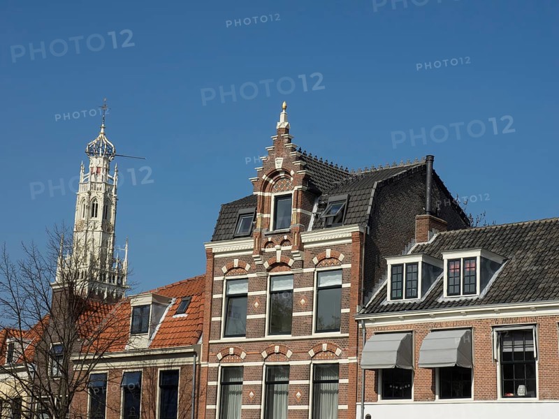 Beautifully decorated historic buildings and a magnificent church tower under a clear blue sky, Haarlem, Netherlands