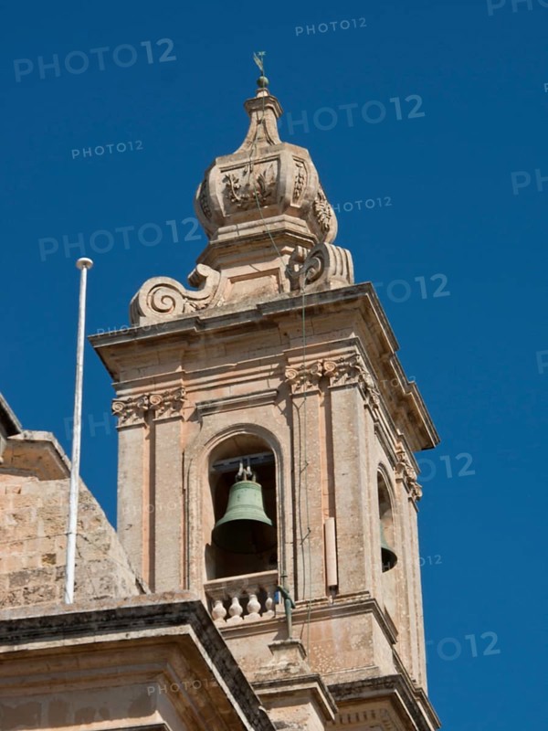 Detailed view of a baroque bell tower with decoration and blue sky in the background, Historic buildings with beautiful windows, balconies and small towers, Mdina, Malta, Europe