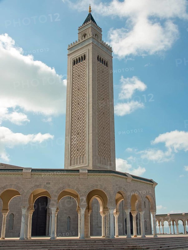 High minaret of a mosque in front of a clear blue sky, Tunis in Africa with ruins from Roman times, modern mosques and blue and white houses in sidi-bou-said, Tunis, Tunisia, Africa