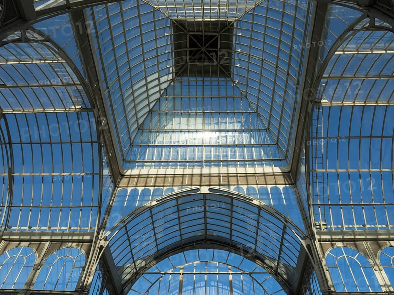 View upwards to the glass ceiling of a greenhouse reflecting in the sun, Madrid, Spain, Europe