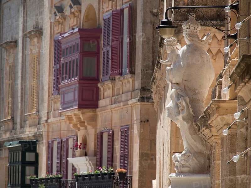 A building facade with colourful shutters, balconies and a statue, the town of mdina on the island of malta with historic houses, colourful balconies, magnificent churches, mdina, Malta, Europe