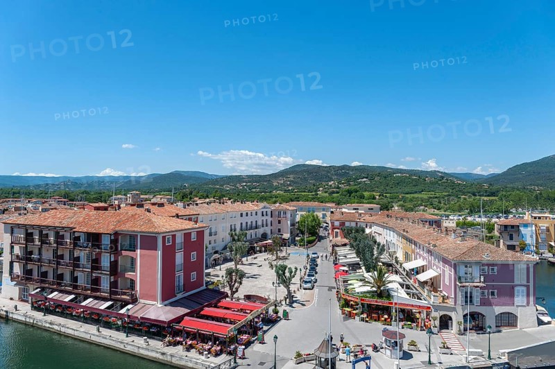 Market square with shops and restaurants, in the background the hills of the Massif des Maures, Port Grimaud, Var, Provence-Alpes-Cote d Azur, France, Europe