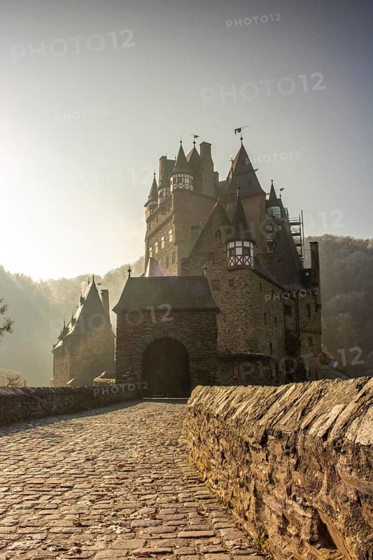 View of Eltz Castle. A landscape in autumn on a frosty morning with ripe and fog. The famous castle is in a valley and surrounded by forest from the 12th century in Wierschem, Rhineland Palatinate Germany
