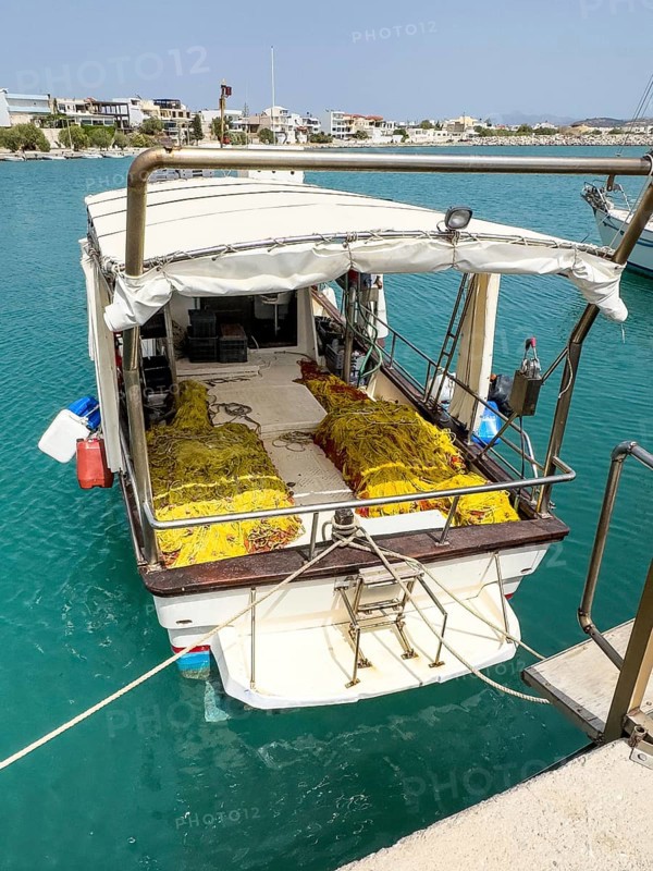 Fishing boat moored to quay wall in Kokkinos Pyrgos harbour, yellow fishing nets on board, Kokkinos Pyrgos, Crete, Greece, Europe