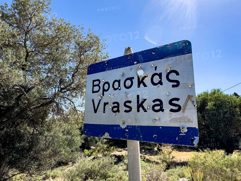 Bullet holes in town sign is target for target practice perforated by bullets, Crete, Greece, Europe