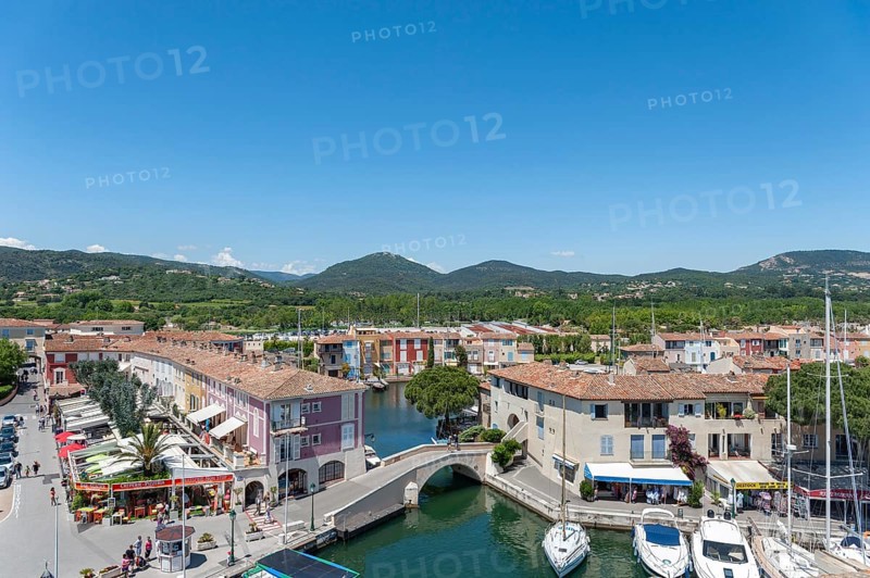 Market square with shops and restaurants, in the background the hills of the Massif des Maures, Port Grimaud, Var, Provence-Alpes-Cote d Azur, France, Europe