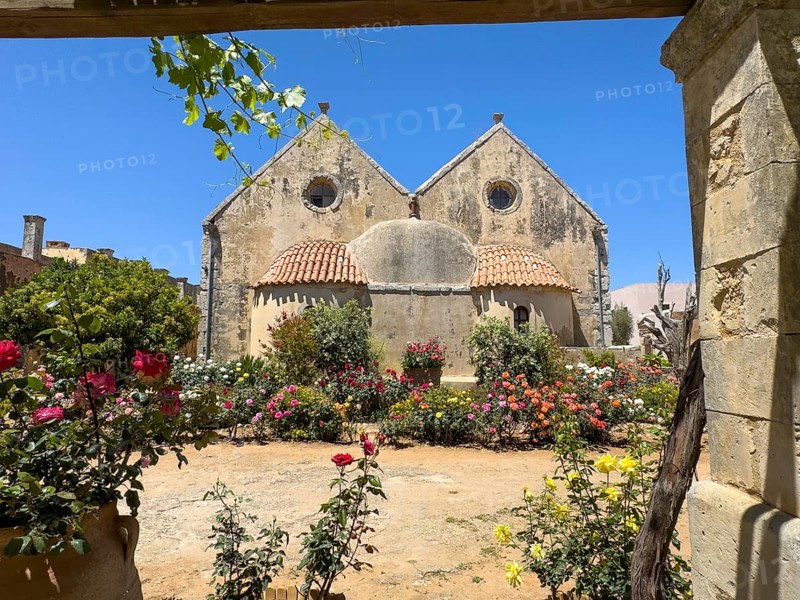 View of rear wall of double-aisled church building Church of Arkadi Monastery with double apse in the foreground blooming flowers and shrubs in UNESCO World Heritage Site Orthodox Monastery of Moni Arkadi Arkadi Monastery from early Middle Ages, important national monument national shrine on Crete island, Arkadi, Armnatos, Crete, Greece, Europe