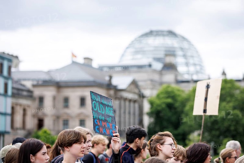 Demonstrators with signs at Fridays for Future in front of the Reichstag building, taken during the climate strike for the EU elections in Berlin, 31 May 2024