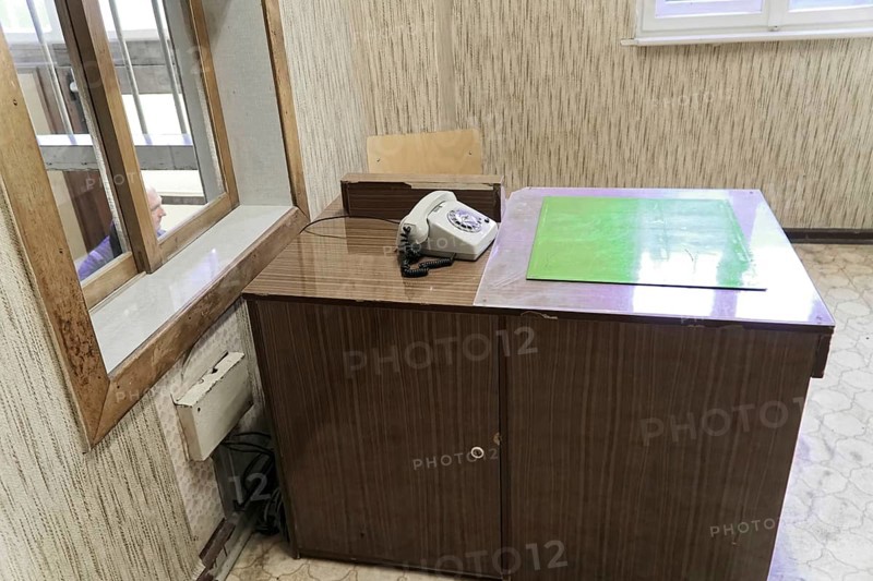 Abandoned, old-fashioned desk with telephone. Illuminated window and wooden panelling on the walls, Berlin-Hohenschoenhausen Memorial, former headquarters, Stasi remand prison, Berlin, Germany, Europe