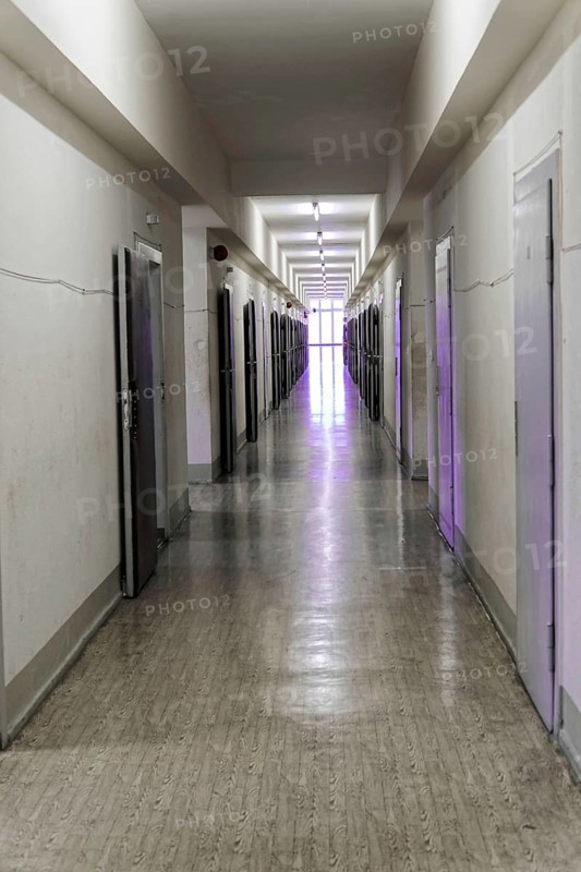 Narrow corridor with neon lights and open doors leads into the distance, Berlin-Hohenschoenhausen Memorial, former headquarters, Stasi remand centre, Berlin, Germany, Europe