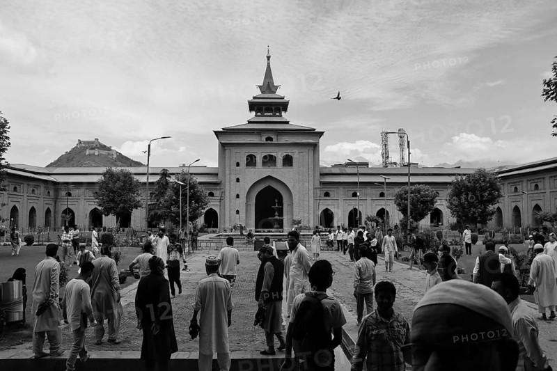 Black and white image of people in the courtyard of a large mosque with historical architecture, Srinagar, Jammu and Kashmir, India, Asia