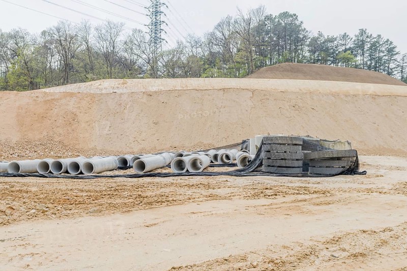 Concrete culvert pipes at base of dirt hillside at rural construction site in Daejeon, South Korea, Asia