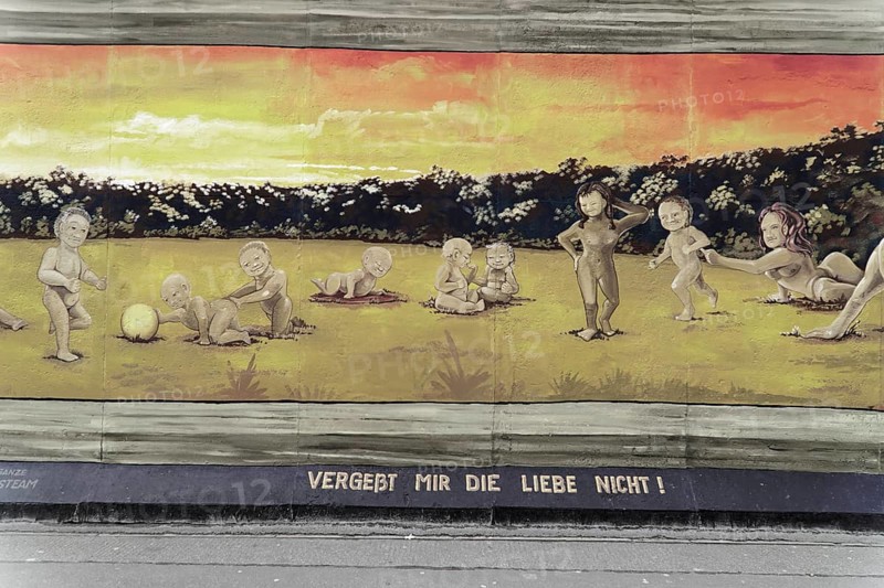 Graffiti on the Berlin Wall at the East Side Gallery, Berlin, Germany, Europe, A peaceful graffiti depicting a group of children in a meadow at sunset, East Side Gallery, Warschauer Strasse, Europe