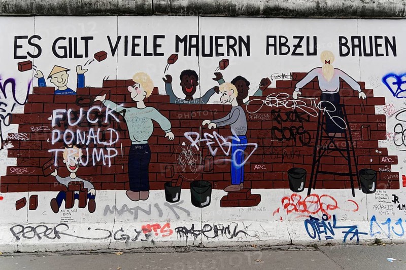Murals of children building a wall, with political message and graffiti, murals, East Side Gallery, Mauergalerie, Berlin, Germany, Europe