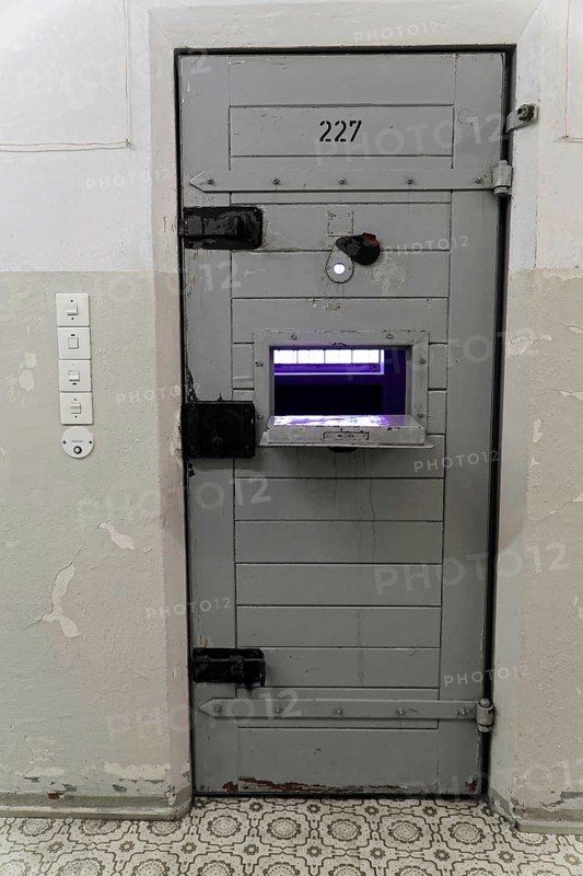 Close-up of a security prison door with food window and worn walls, Berlin-Hohenschoenhausen Memorial, former headquarters, Stasi remand centre, Berlin, Germany, Europe